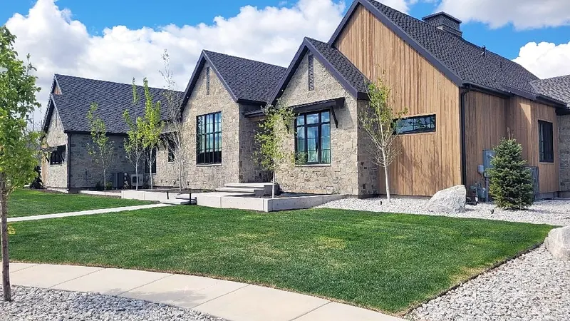 Farmhouse front yard with new sod and rock borders