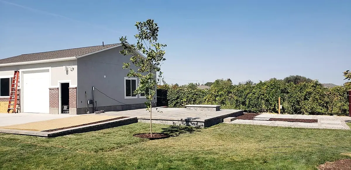 New lawn and tree beside a detached shop