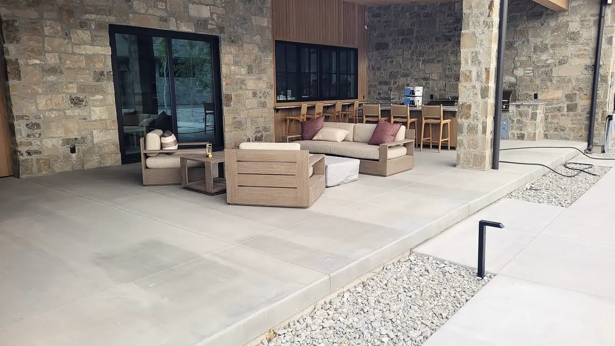 Covered concrete patio with a gravel border