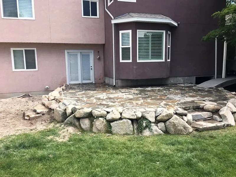 Flagstone patio held by a boulder wall