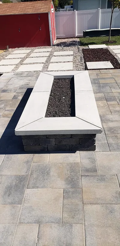 Large-format paver patio with a stone-capped planter