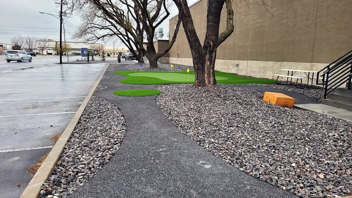 Rock beds and a putting green along a walking path