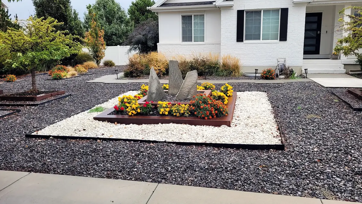 Steel flower planter framed in white and black rock