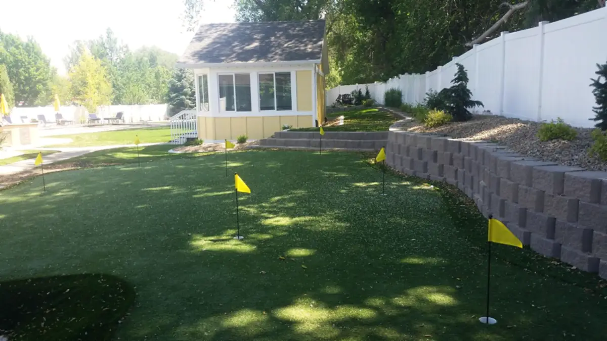 Putting green below a block wall