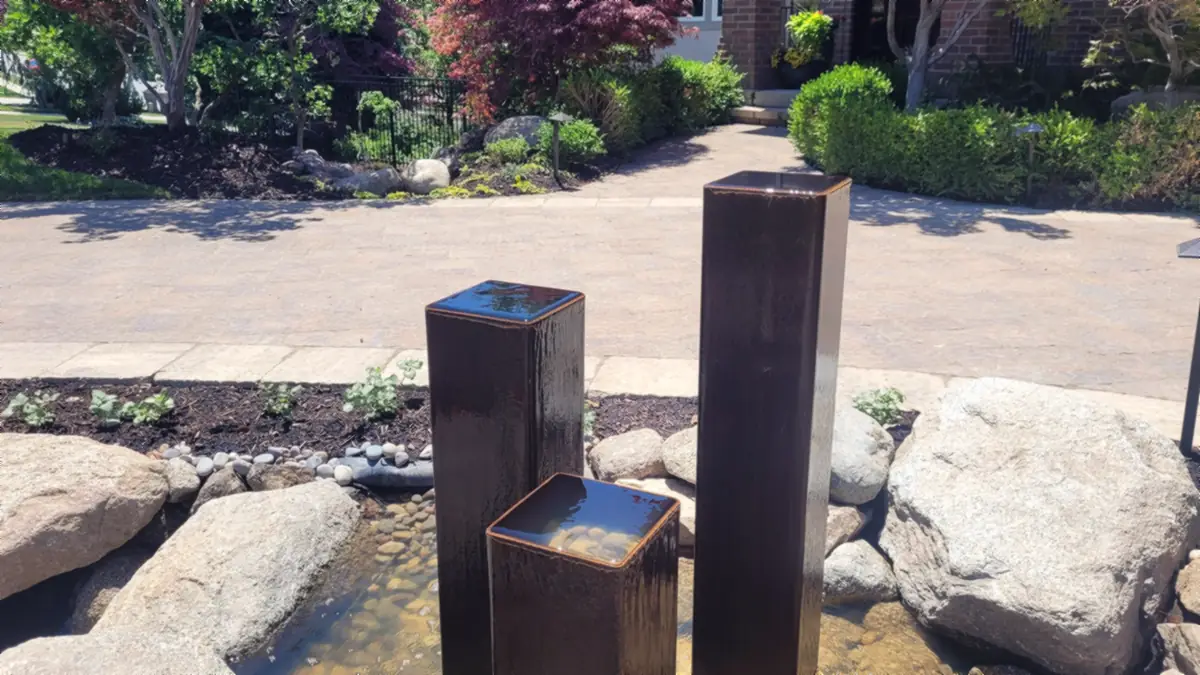 Three steel water columns and boulders