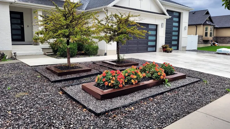 Rusted steel planters in a rock front yard